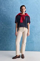 Jean de tiro alto y corte recto, confeccionado en denim con spandex para mayor comodidad y ajuste. Presenta un diseño clásico de cinco bolsillos y cierre frontal con botón y cremallera.