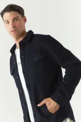 Chaqueta azul marino de paño con cuello clásico, cierre frontal con botones, dos bolsillos de parche en el pecho con solapa abotonada y bolsillos laterales.