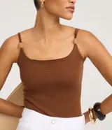 Body femenino ajustado, sin mangas, color verde oliva, con escote cuadrado y breteles finos dobles adornados con piezas decorativas. El tejido es texturizado.