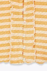 Top chaqueta de punto a rayas horizontales rojas y blancas, con escote pico, manga corta y volantes. Cierre frontal con botones.