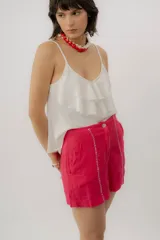 Musculosa negra con escote en V, breteles finos regulables y doble volado frontal con pespuntes.