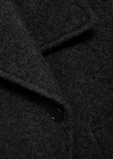 Abrigo corto de corte oversize confeccionado en mezcla de lana, con cuello de solapas con muesca, cierre frontal de doble botonadura y dos bolsillos de ribete laterales.