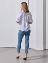 Blusa color fucsia con estampado de rayas verticales y flores, cuello redondo con escote en V y mangas cortas abullonadas.