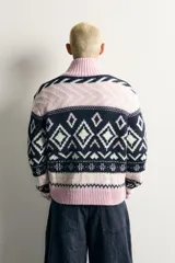 Chaqueta de punto relaxed fit tejida con mezcla de lana, con diseño de rombos y patrones geométricos en tonos azul marino, blanco y rosado. Cuenta con cuello alto, manga larga, acabados en rib y cierre frontal con cremallera de doble dirección.