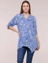 Blusa azul con estampado floral, escote en V, abotonadura frontal y mangas tres cuartos con presilla para arremangar. Cuenta con un diseño amplio y ruedo asimétrico en punta.