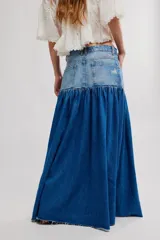 Falda maxi de denim con canesú de tiro alto y cuerpo fruncido, abertura frontal y ruedo sin terminar. Combina paneles con diferentes lavados de jean.
