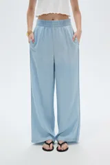 Pantalón celeste de lyocell, de corte ancho y tiro alto, con bolsillos laterales.