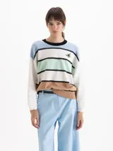 Sweater Clover de tejido semi liviano, de calce oversize con escote redondo, hombros caídos y mangas largas. Su diseño a rayas horizontales combina celeste, blanco, verde menta, negro y marrón, e incluye un bordado de abeja en el frente.