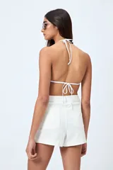 Short blanco de algodón con elastano, calce medio, bolsillos funcionales y tajos pequeños en el ruedo.