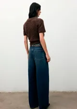 Chaleco de tejido bouclé color marrón, con cuello redondo y manga corta. Presenta un diseño recto y textura suave.