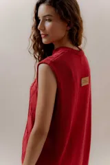 Vestido corto tejido color rojo, sin mangas y con cuello redondo.