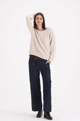 Sweater de tejido de punto en color beige con detalles de terminación en color chocolate en cuello, puños y ruedo. Presenta un diseño de corte holgado con mangas largas y cuello redondo amplio.