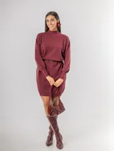Vestido tipo polerón de tejido de punto color borgoña, con cuello alto, mangas largas con puños ajustados y corte recto. Incluye un cinturón del mismo material con una hebilla decorativa de flor con cristales.