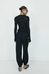 Pantalón de tiro medio con cintura elástica ajustable mediante cordones. Presenta bolsillos delanteros y bajos terminados en puño elástico con detalle de botón.