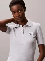 Chomba de Calvin Klein Jeans confeccionada en tejido de algodón con elastano, de corte regular y textura acanalada. Presenta cuello tipo polo con cartera de dos botones y una insignia distintiva de la marca aplicada en el pecho.