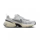 Championes Nike V2K Run con diseño retro inspirado en los años 2000. Presentan una combinación de malla técnica y superposiciones de cuero sintético metalizado en color plata. Incluyen una entresuela de espuma de doble densidad en tono crema con detalles en negro y suela de goma resistente.