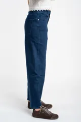 Jean de corte baggy con tiro medio, confeccionado en denim de algodón. Presenta un diseño de pierna ancha con estructura curva tipo barril y cierre frontal con botón y cremallera.