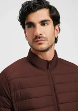 Campera puffer color beige con cierre frontal y bolsillos laterales.