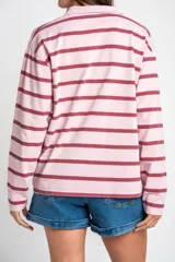 Sweater tipo polo de manga larga con diseño a rayas horizontales en tonos rosado y bordó. Presenta cuello camisero con solapa y cierre frontal parcial.