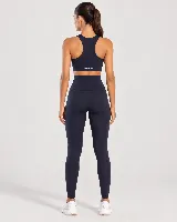 Calza deportiva larga de color negro, de tiro alto y diseño modelador, confeccionada con tejido de alta elasticidad y tacto suave.