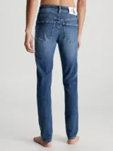 Jeans de mezclilla elástica de algodón, color azul medio con efecto desgastado y lavado. Presentan un corte skinny fit, cintura de talle bajo, bragueta con cremallera y estilo de 5 bolsillos.