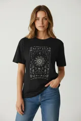 Remera de algodón color negro, de corte holgado y manga corta, con cuello a la base y estampado frontal con detalles de strass.