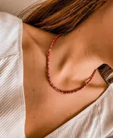 Gargantilla de cuentas pequeñas color rojo con detalles plateados.