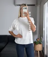 Blusa de símil lino color beige, con cuello redondo fruncido, doble volado en los hombros con detalle de encaje y manga 3/4.