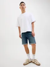 Bermuda de jean azul con efecto gastado y dobladillo revuelto en las piernas, de corte clásico.