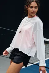 Buzo de manga larga blanco, de silueta boxy y calce ligeramente cropped, con escote redondo y terminaciones sin rematar.