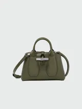 Cartera de mano modelo Le Roseau XS de Longchamp, confeccionada en cuero color verde oliva. Presenta un diseño estructurado con el icónico cierre de bambú metálico en la parte frontal y doble asa corta.