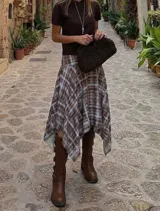 Pollera midi de corte asimétrico con diseño irregular y estampado cuadrillé en tonos marrón y celeste. Presenta cintura alta y silueta fluida con caída liviana.