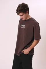 Camiseta de manga corta, color gris oscuro con efecto lavado, corte oversize y cuello redondo. Presenta un pequeño estampado en el pecho con el texto "CREW MEMBER" en blanco.