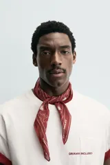 Pañuelo cuadrado (bandana) color bordó con estampado de corazones blancos y líneas curvas que forman un patrón de rejilla.