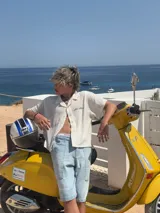 Camisa de waffle color crema con cuello polo, mangas cortas y bordado marrón en la espalda.