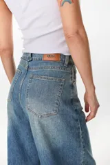 Jean de corte wide leg, tiro alto y lavado azul medio, con diseño relajado y moderno.