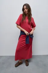 Vestido midi negro de algodón con calce relajado, silueta recta, cuello redondo, mangas cortas amplias y tajos laterales.