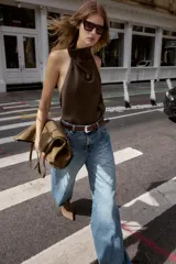 Top blanco satinado con cuello halter y escote fluido. Cierre en la espalda con botones.