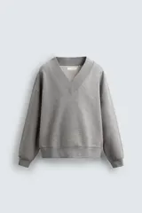 Sudadera de corte relajado confeccionada en algodón con interior de rizo. Presenta cuello en pico y manga larga con acabados en rib.