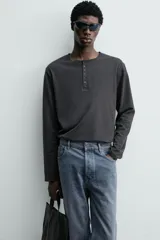 Camiseta de manga larga con cuello redondo y cierre frontal de botonadura tipo henley. Confeccionada en tejido de algodón y seda, con un corte relajado.