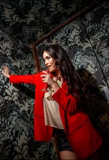 Blazer rojo de crepé elastizado, con solapas clásicas y bolsillos frontales.