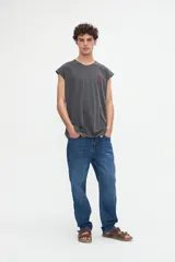 Musculosa gris oscuro con efecto lavado, corte relaxed y estampa en la espalda con la frase "Beyond the noise find your signal" en tono bordó.