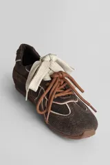 Championes deportivos color marrón con diseño de líneas onduladas en tono claro, cordones al tono y suela de goma.