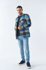 Sobrecamisa de algodón a cuadros color ladrillo, con interior de corderito, cierre con botones, bolsillos tipo cartera y logo en goma. El modelo usa talle M.