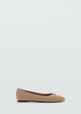 Zapato tipo ballerina de cuero caprino color beige, con punta redondeada y lazo decorativo en la parte frontal.