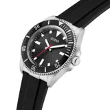 Reloj analógico Guess con caja de acero inoxidable, esfera negra con índices luminiscentes y segundero rojo, y malla de silicona negra.