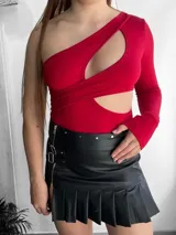 Mini pollera negra de cuero sintético con tablas y cierre lateral.