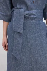 Falda midi color marrón de lino con bolsillos laterales y volante en el ruedo. Tiene una tira en la cintura para anudar en la delantera.