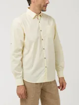 Camisa de manga larga RKF modelo Galiton, confeccionada en popelina de algodón orgánico color amarillo. Presenta cuello camisero, cierre frontal con botones de madera, bolsillo en el pecho con logo bordado y mangas ajustables.