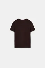 Camiseta de algodón color marrón oscuro, de corte regular, cuello redondo y manga corta. Presenta una estampación metalizada dorada en el parte frontal con texto "REYKJAVIK ART GALLERY" y "ABSTRACT MOVEMENTS Reykjavik, Iceland, 1975".